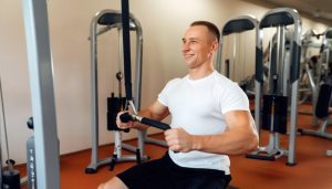 un homme avec le sourire fait des exercices dans une salle de fitness